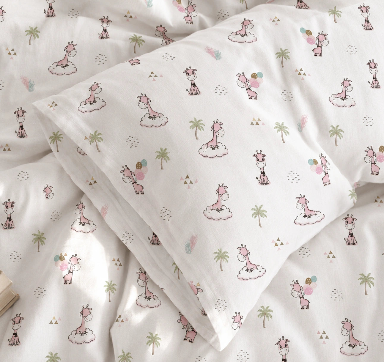 White bedding set with a whimsical giraffe and palm tree print, including a duvet cover and matching pillowcases.